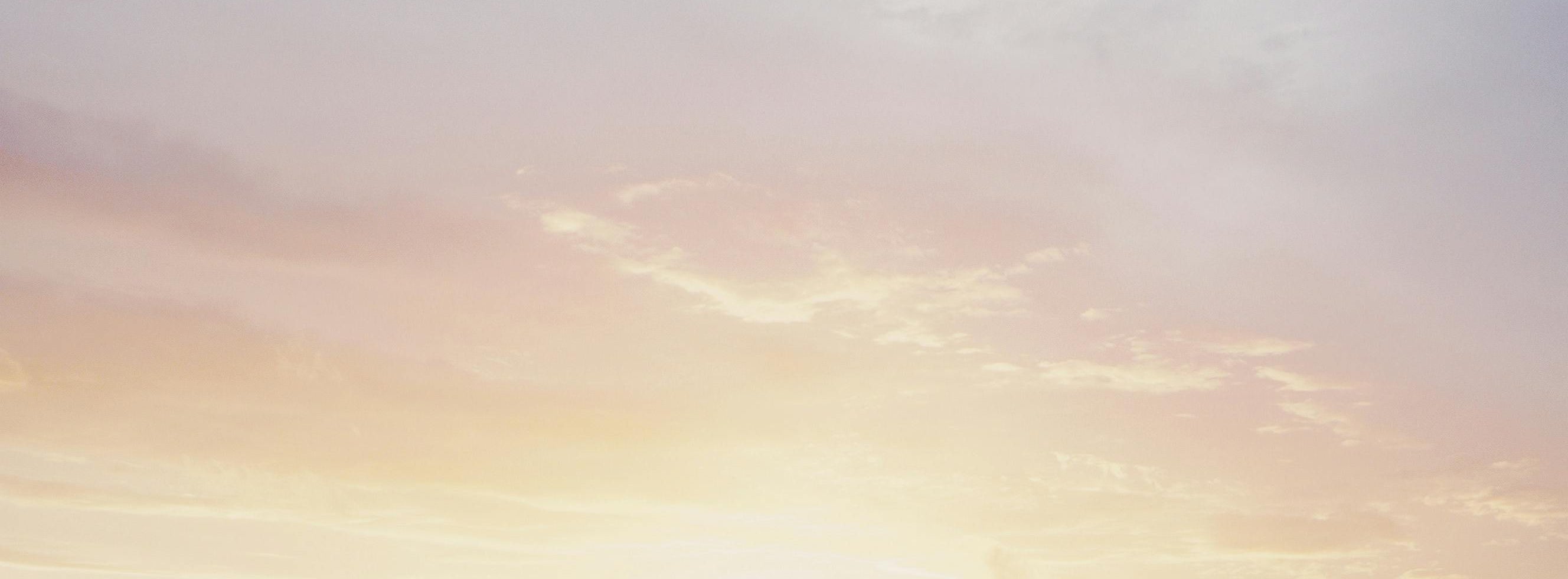 Beautiful sunrise sky with warm hues of orange and pink over rolling hills near a sustainable forest, symbolizing a fresh start and eco-friendly living.